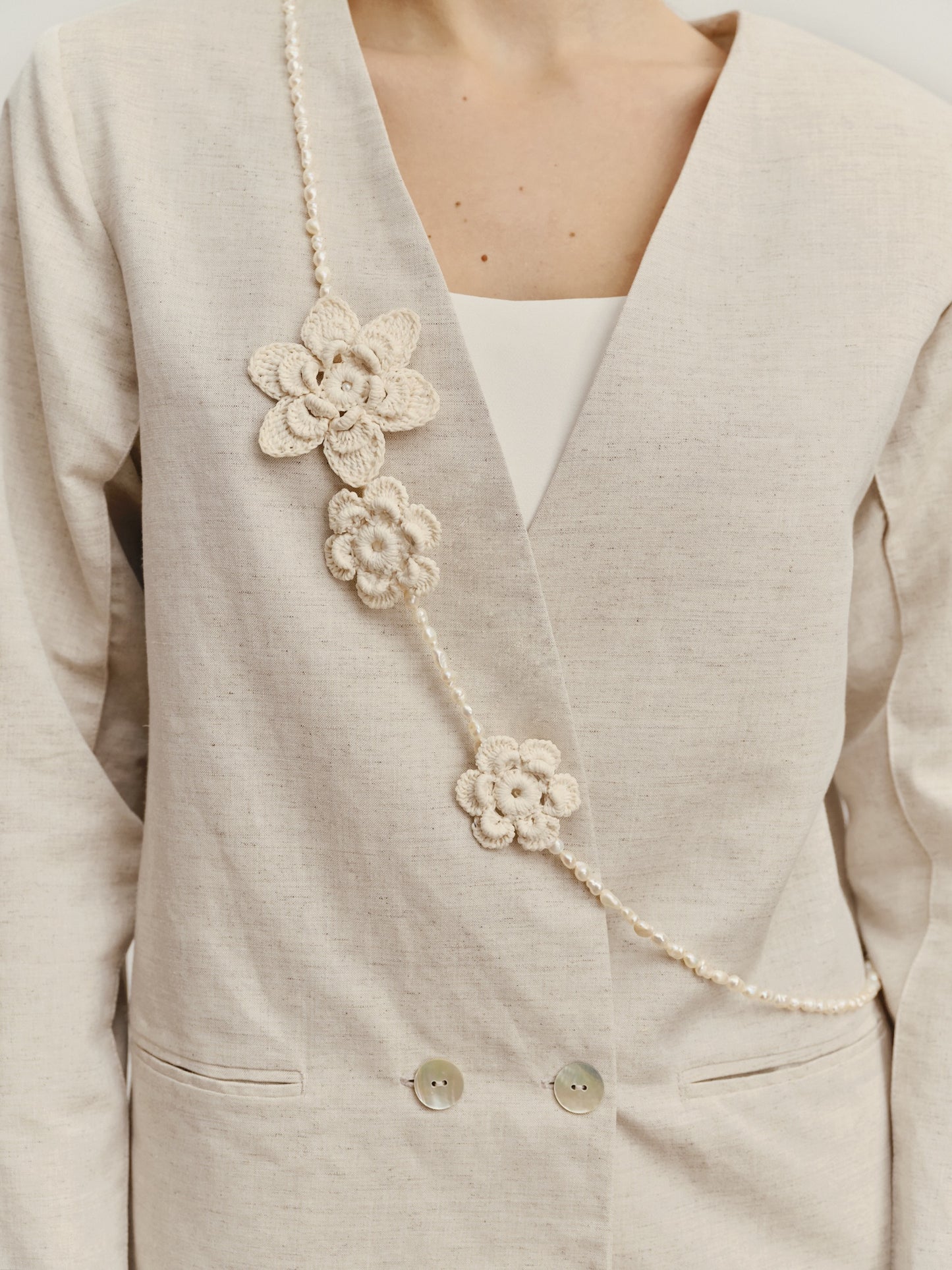 Necklace from natural pearls and knitted flowers